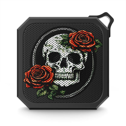 front of a skull and rose bluetooth speaker