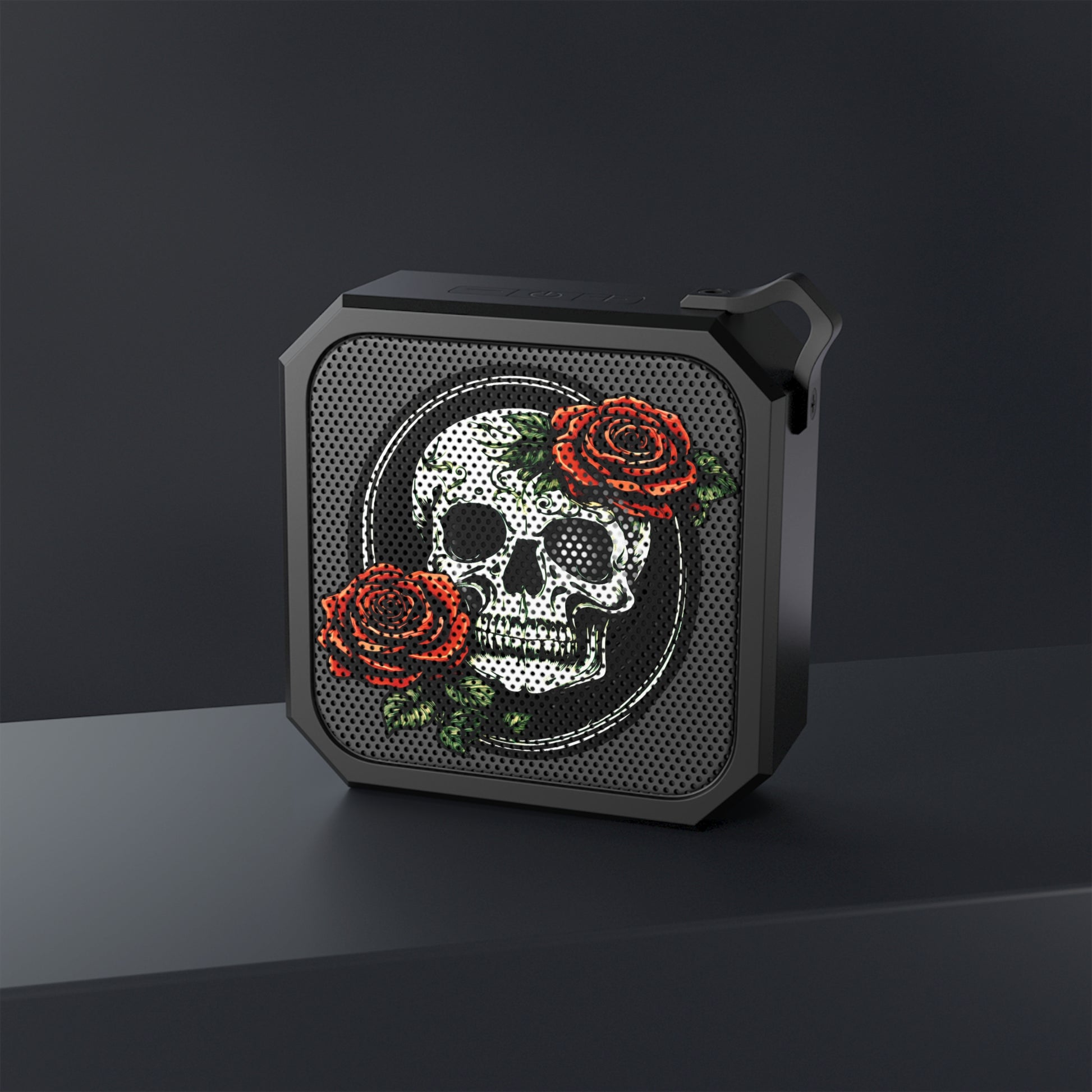 a skull and rose bluetooth speaker displayed in front of a black background